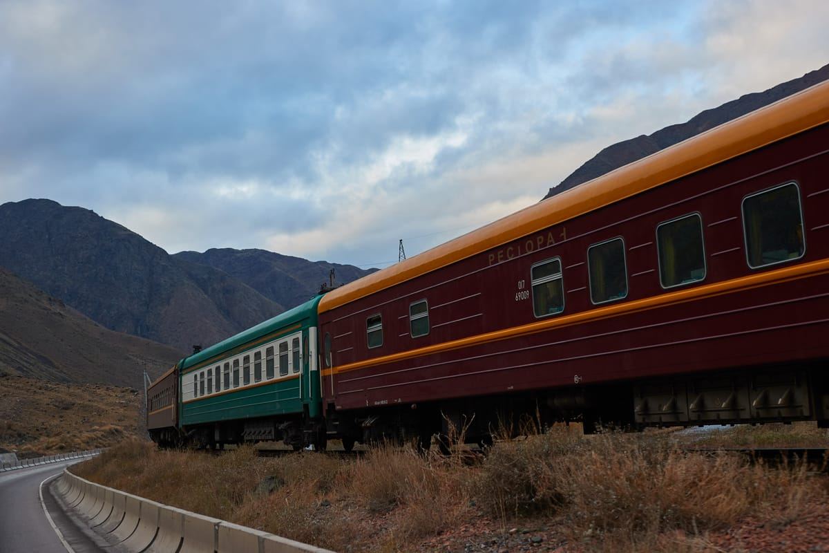 Der Orient Silk Road Express in einer weiten Kurve vor den Bergen Zentralasiens